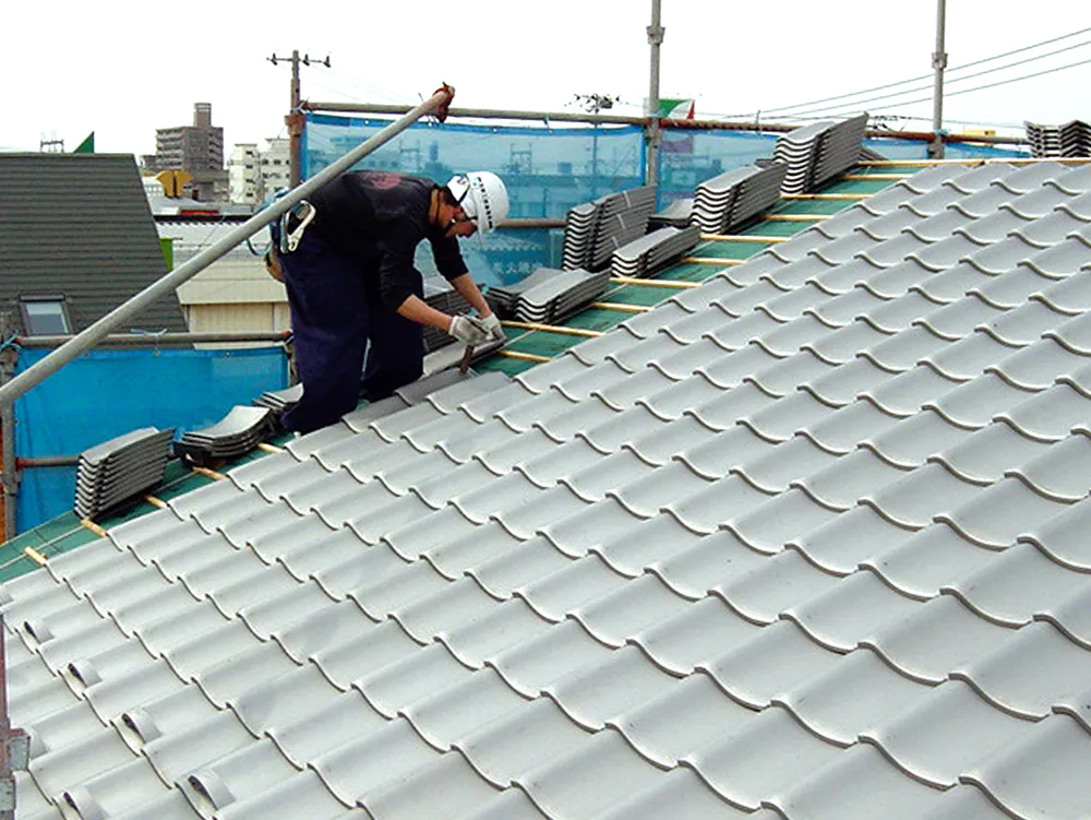 屋根で作業する男性の写真